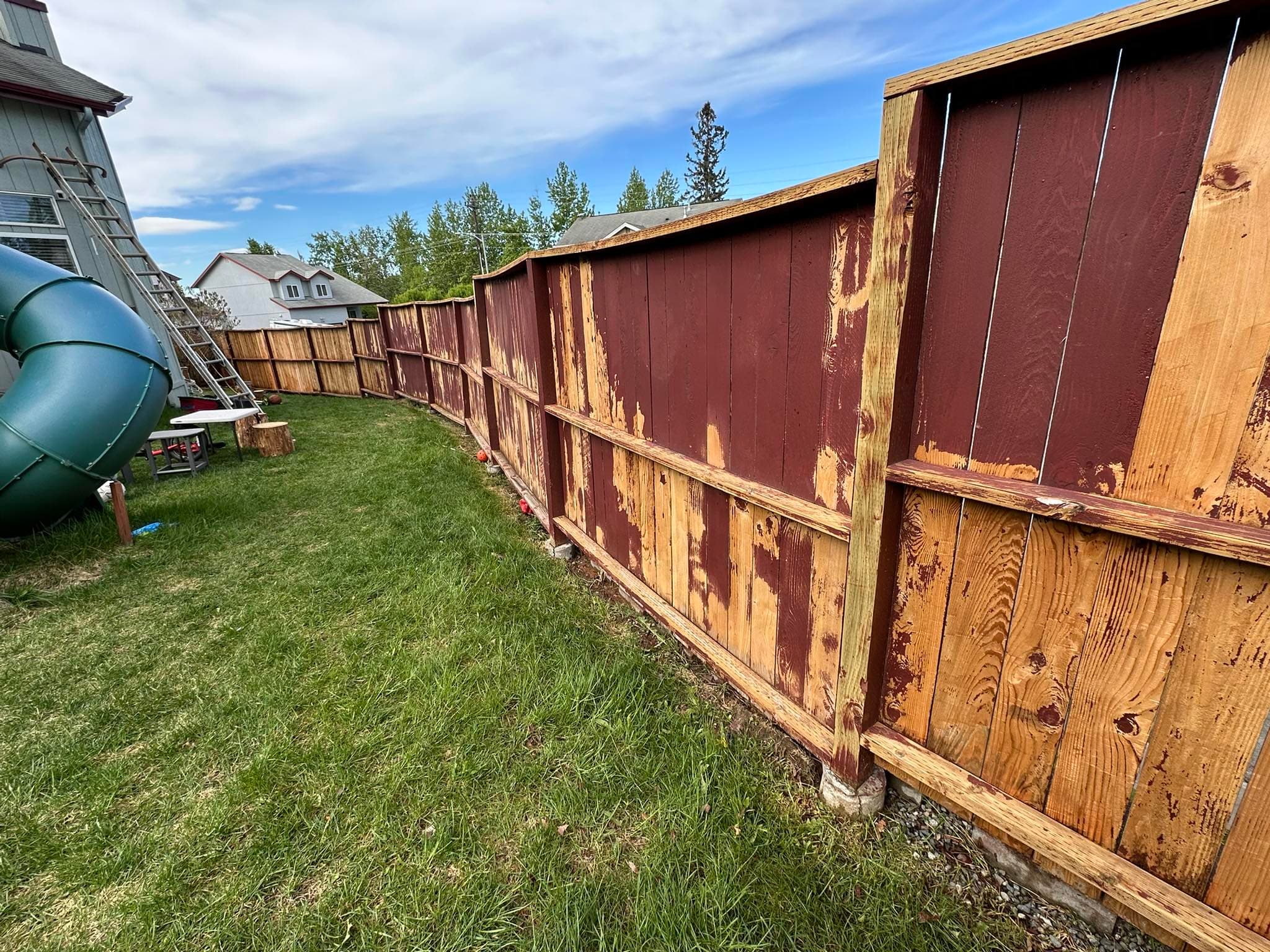 Fence before painting — peeling brown paint on raw wood