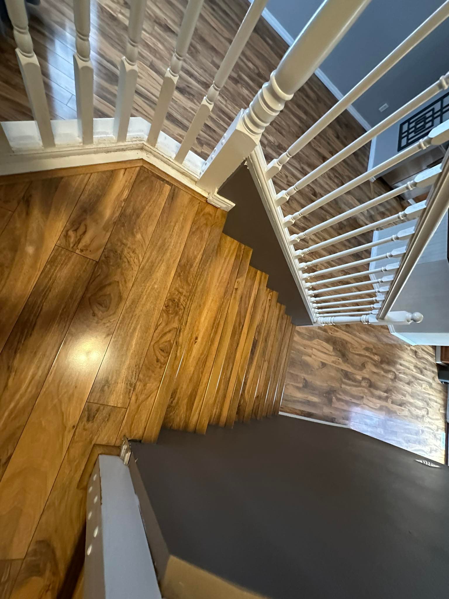 Aerial view of hardwood staircase installation with white railings