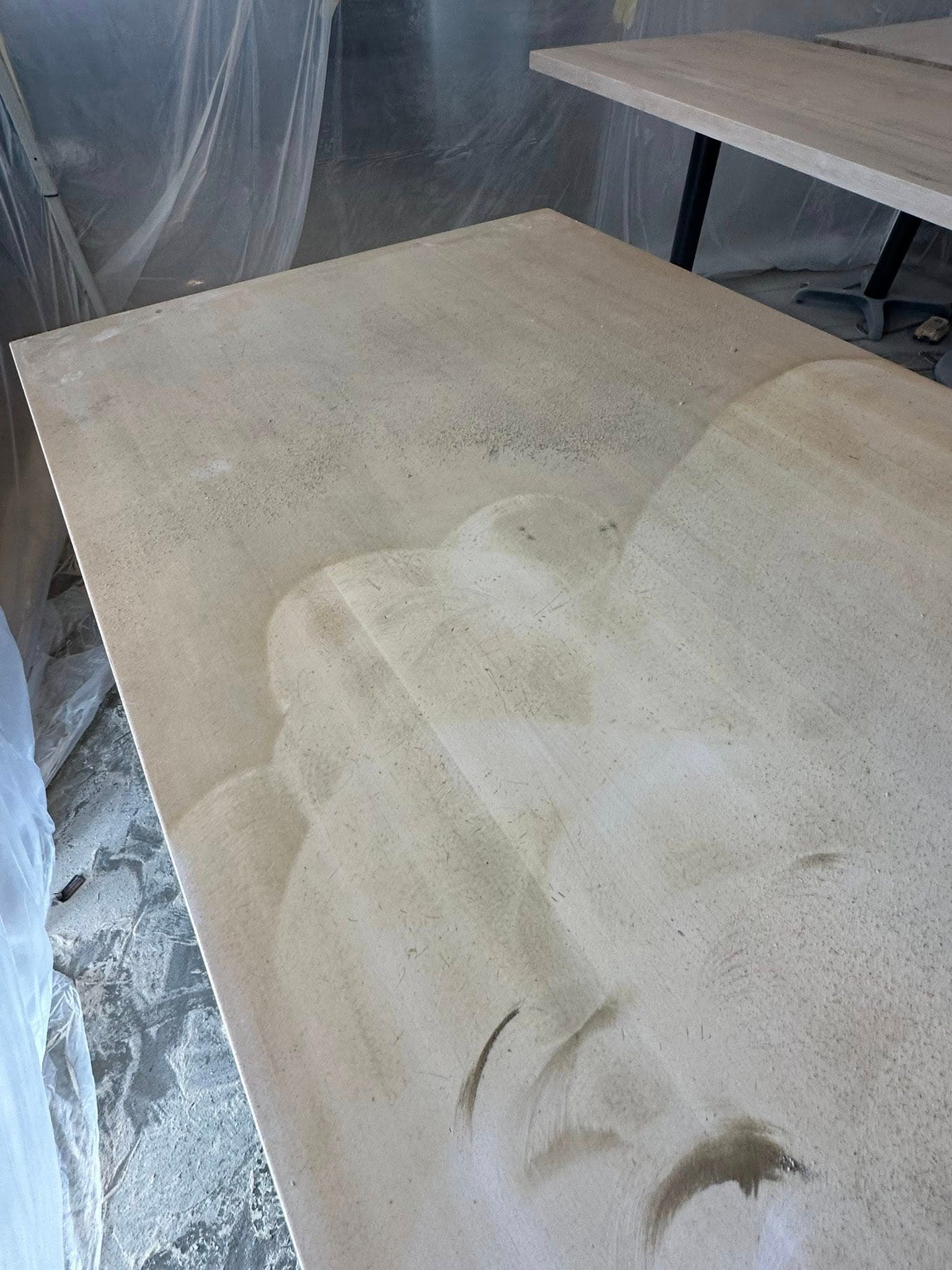 Restaurant tables before refinishing — raw sanded surface
